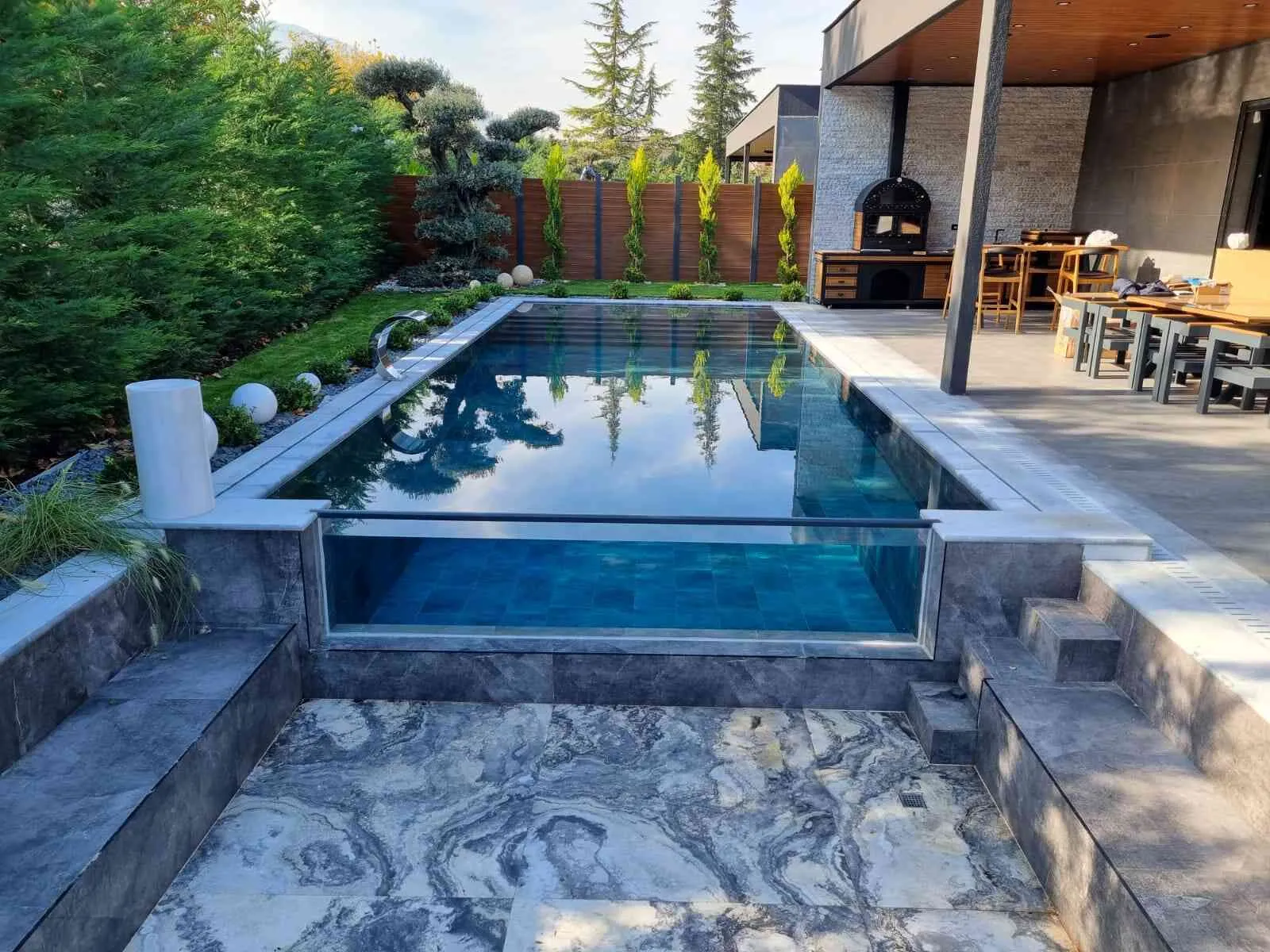 Berrak suyu ve estetik tasarımıyla göz kamaştırıcı bir yüzme havuzu.